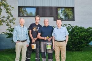 Onnexi Oy:tä edustava Matti Kontio maalipurkkikädessä kolmen muun miehen kanssa taloyhtiön pihalla.